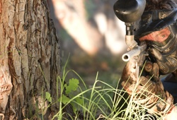 Paintball sniper by a tree